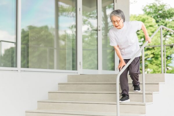 リハビリで階段の昇り降りをする高齢者女性